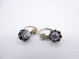 a pair of black and white crystal earrings on a white surface