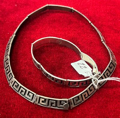 deux bracelets en argent posés sur un fond rouge, accompagnés d'une étiquette