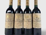 three bottles of red wine are lined up on a white surface