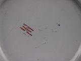 a close up of a white plate with red writing on it