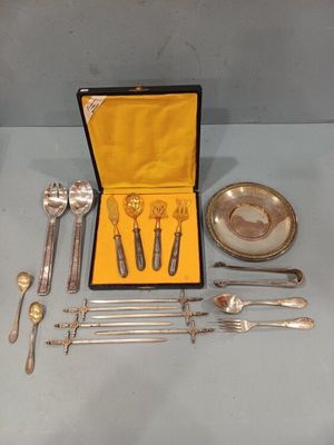 un service d'argenterie dans un coffret posé sur une table