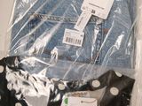 three pairs of jeans in a plastic bag on a table