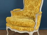 une chaise jaune posée sur un parquet, près d'un mur bleu
