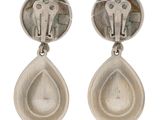 pair of silver earrings with green stones on them on a white background