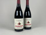 deux bouteilles de vin rouge posées l'une à côté de l'autre sur une table