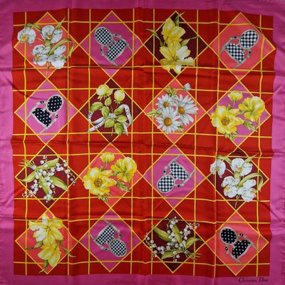un gros plan sur une couette rouge et jaune ornée de fleurs