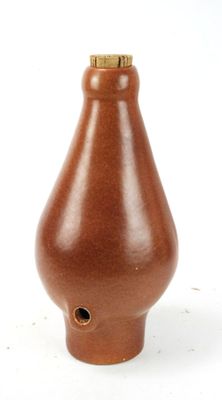 a brown vase that is sitting on a white surface