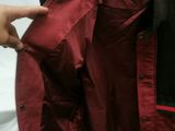 a person holding a jacket on a hanger in a room