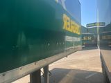 a green trailer with a beer sign on the side of it
