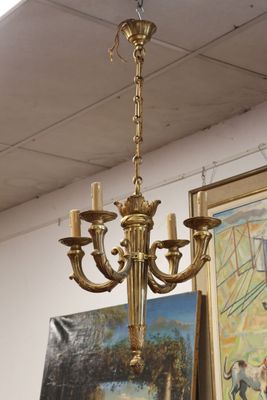 a gold chandelier hanging from a ceiling in a room