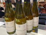 four bottles of white wine are lined up on a counter