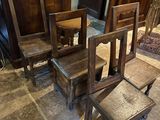 four wooden chairs and a table in a room
