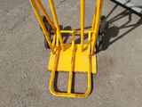a yellow hand truck that is sitting on the ground