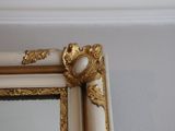 a mirror with a gold frame on the wall