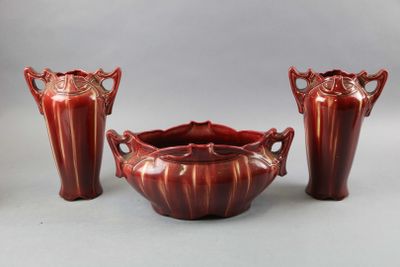 three red vases and a bowl sitting next to each other on a table
