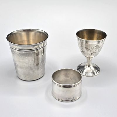 deux tasses en argent posées l'une à côté de l'autre sur une surface blanche