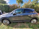 the grey car is parked on the grass in the yard