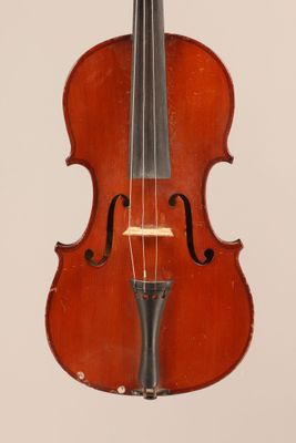 an old violin sitting on top of a table next to a white wall