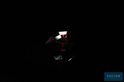 un gros plan d'un diamant dans l'obscurité, éclairé par une source lumineuse