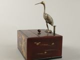 a bird sitting on top of a box on a table
