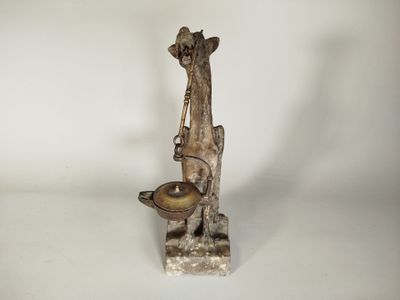 une statue représentant une girafe sur laquelle est posé un bol