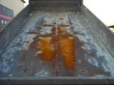a dirty truck bed with rust on the side of it