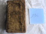 un vieux livre posé sur une table, avec un mot accroché dessus
