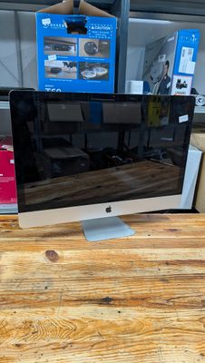un écran d'ordinateur posé sur un bureau en bois
