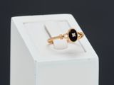 a close up of a gold ring with a black stone on it