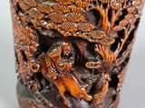 a wooden vase with carvings on it on a table