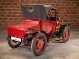 a red and black antique car parked in front of a brick wall