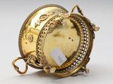 an image of a gold plated clock on a stand with a tag on it