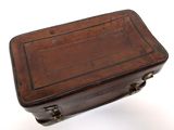 a brown suitcase sitting on top of a white surface