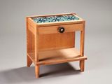 a small wooden table with a drawer on it