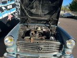 une vieille voiture garée devant un camion
