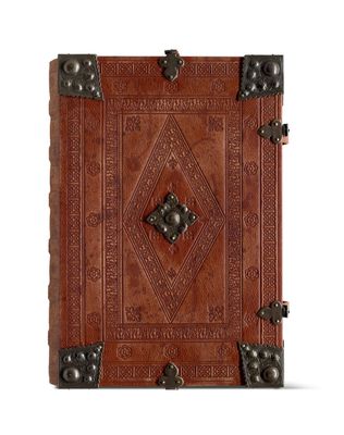 un livre en cuir marron orné d'un motif décoratif sur la couverture