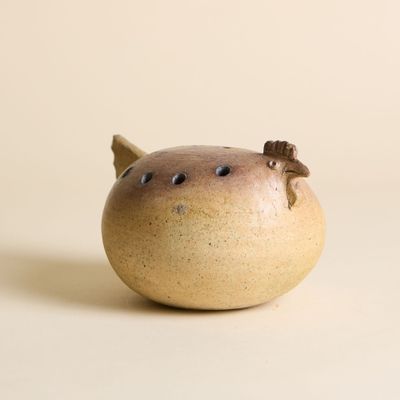 un petit vase avec un oiseau sur une table