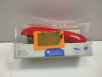 une agrafeuse rouge dans une boîte en plastique posée sur une table