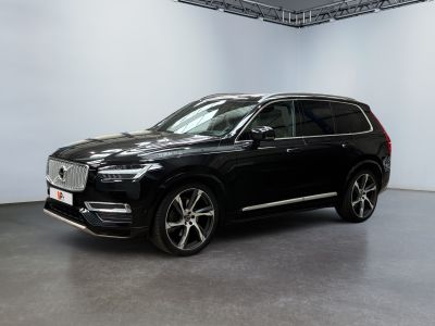 Un SUV Volvo noir est garé dans une grande pièce.