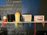une étagère sur laquelle sont posés divers objets, devant un tableau noir