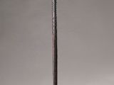 an old wooden stick with a long handle sitting on top of a white surface