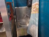 a blue tiled bathroom with a stainless steel sink and a blue towel hanging from the wall