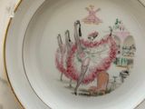 a plate with a picture of a woman and two birds on it