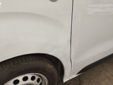 a white van that has been dented and is parked in a garage