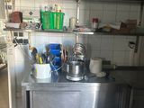 un plan de travail en acier inoxydable sur lequel sont posés des casseroles et des poêles