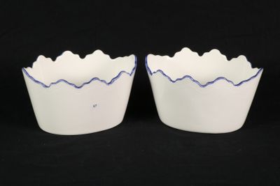 two white bowls with blue lines on them on a black background