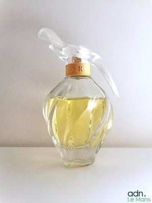 an image of a bottle of perfume sitting on top of a table