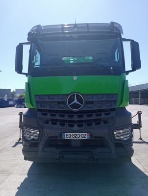 un camion Mercedes vert garé sur un parking
