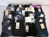 beaucoup de jeans empilés les uns sur les autres sur une table