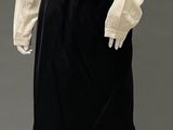 an image of a mannequin wearing a black skirt and a beige shirt